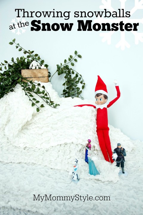 Elf on the shelf throwing snowballs at the snow monster