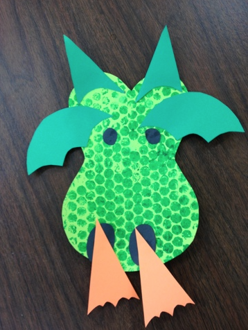 Bubble Wrap Art of a green dragon breathing fire. 
