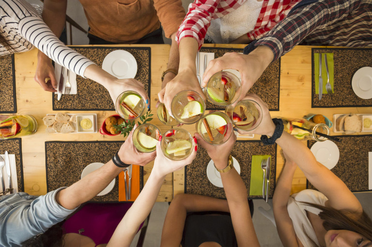 Group of people toasting and looking happy at a restaurant 