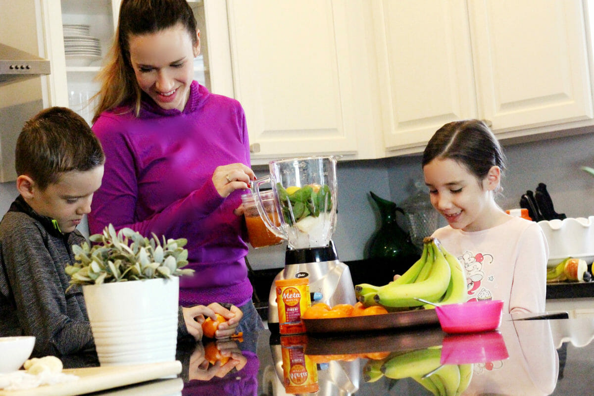 Mom with kids making a smoothie for the Metamucil challenge.