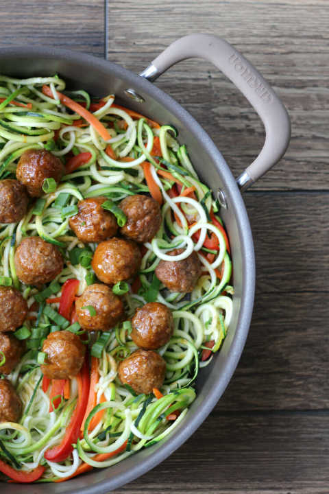 Skillet full of zoodles, red bell pepper, carrots, green onion and Korean BBQ Meatballs.  