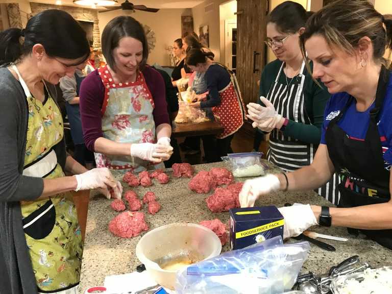 ladies working with ground beef for freezer meal prep