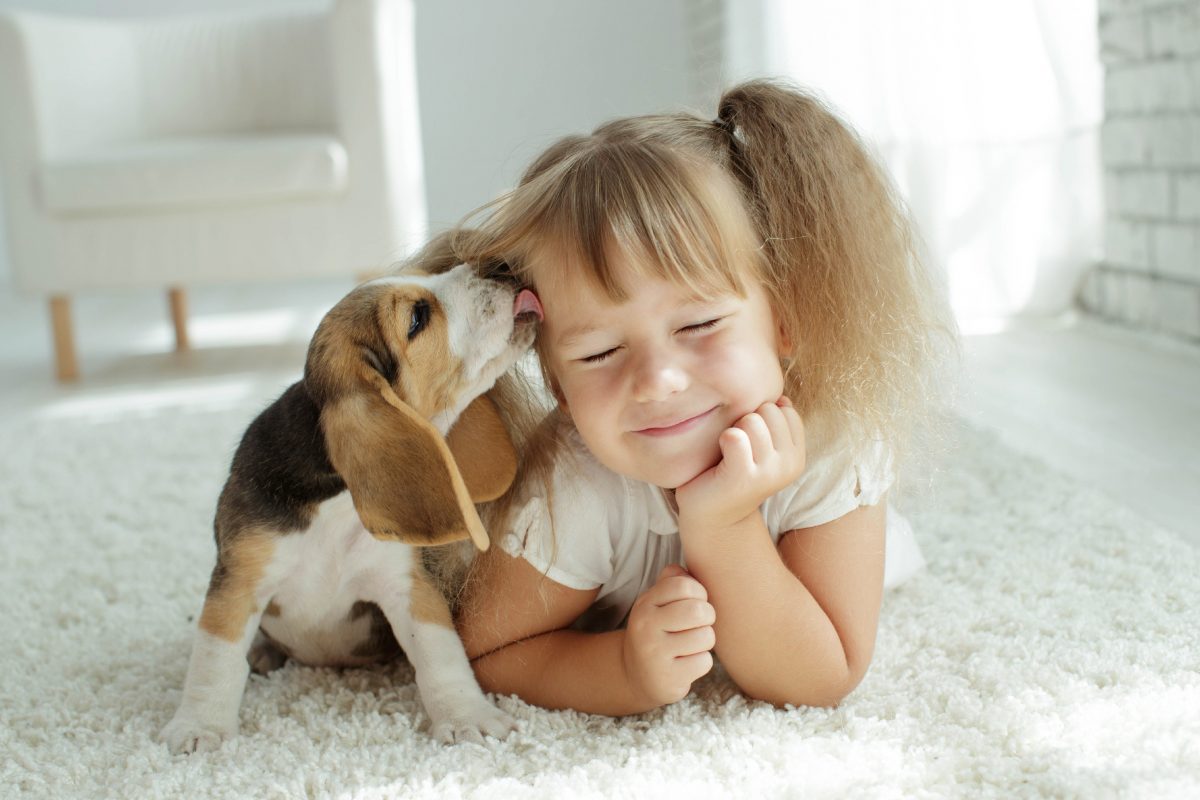 Girl with dog licking her face